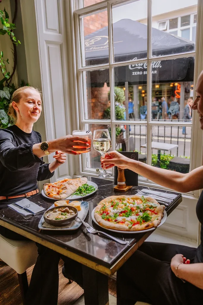Friends enjoying food and drinks together at La Vecchia Scuola in York