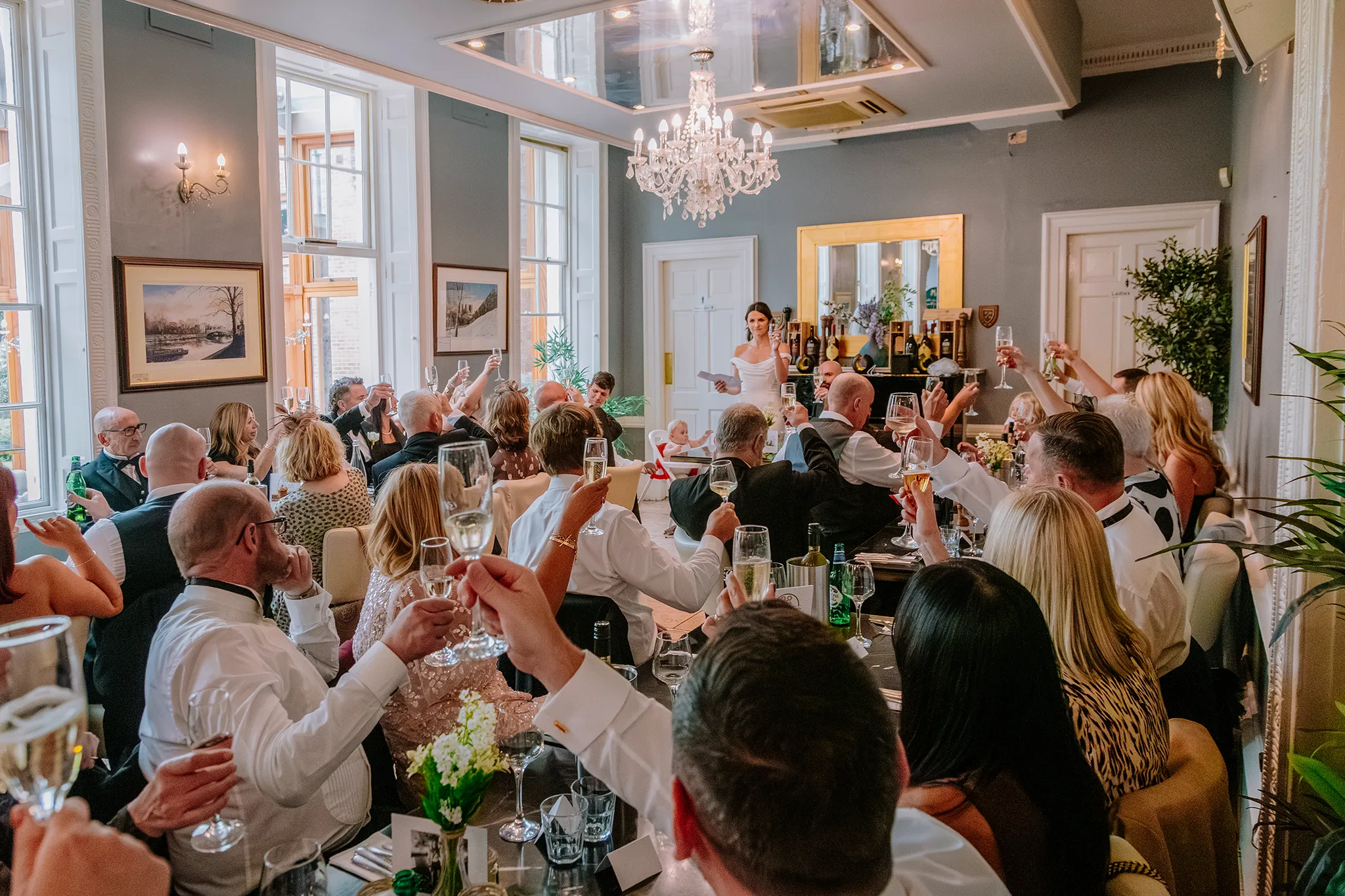 Guests enjoying a private dining celebration at La Vecchia Scuola in York, raising a toast during a wedding reception or special event.